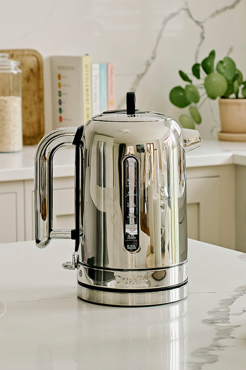                                                                             Traditional, classic design silver kettle on a kitchen counter with a blurred background                                                                     